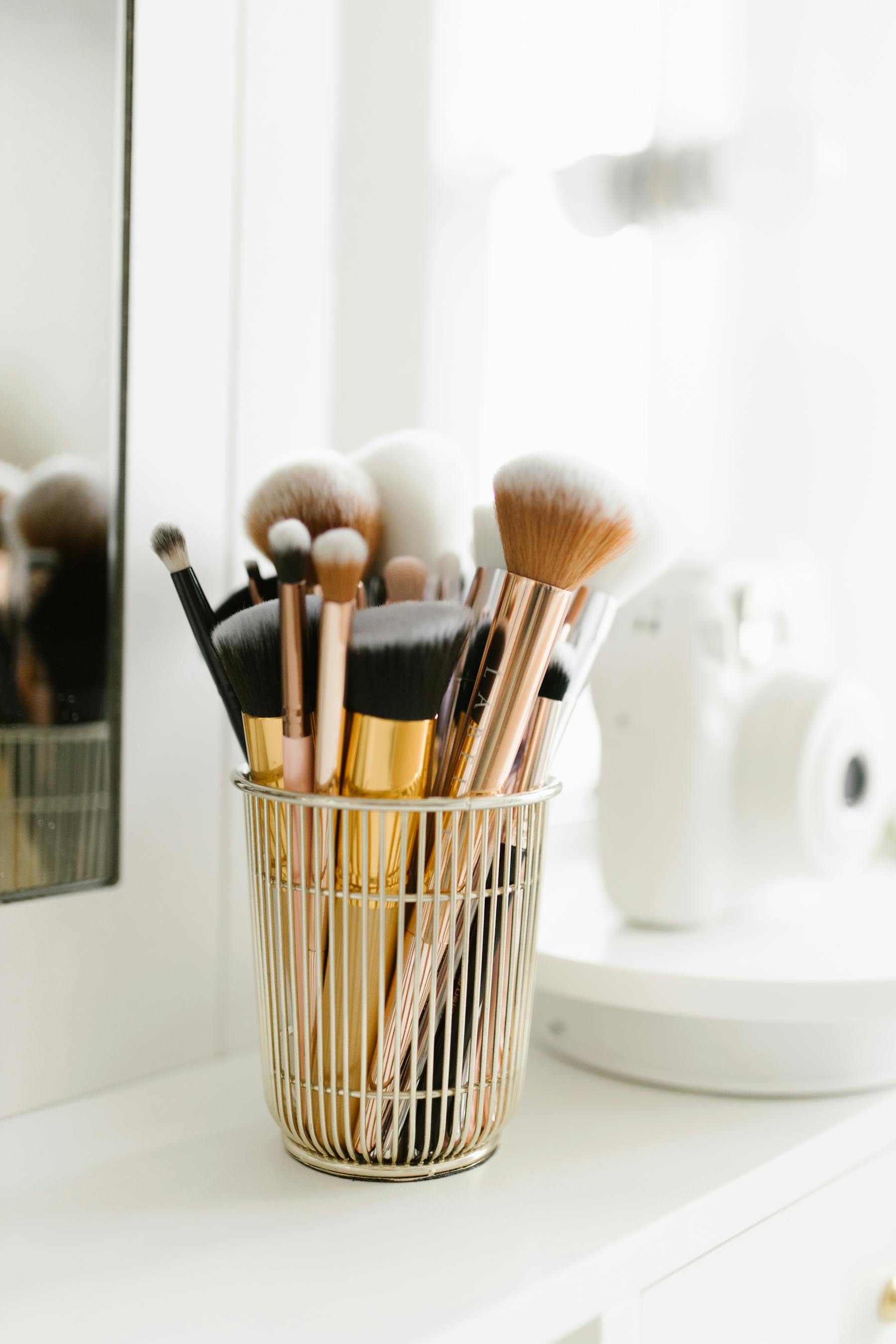 Makeup brushes arranged beside a vanity mirror.